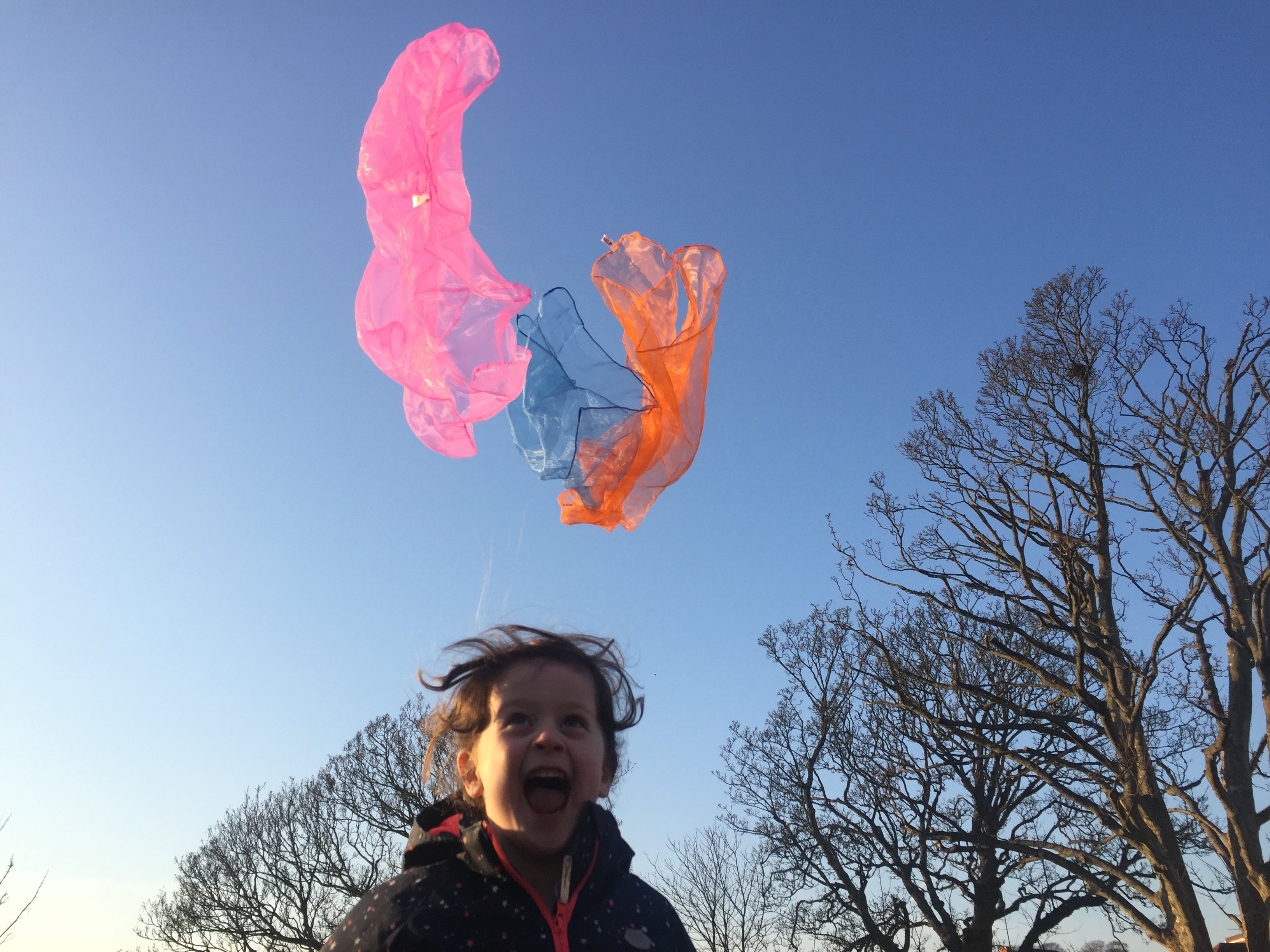 child enjoying juggling with scarves